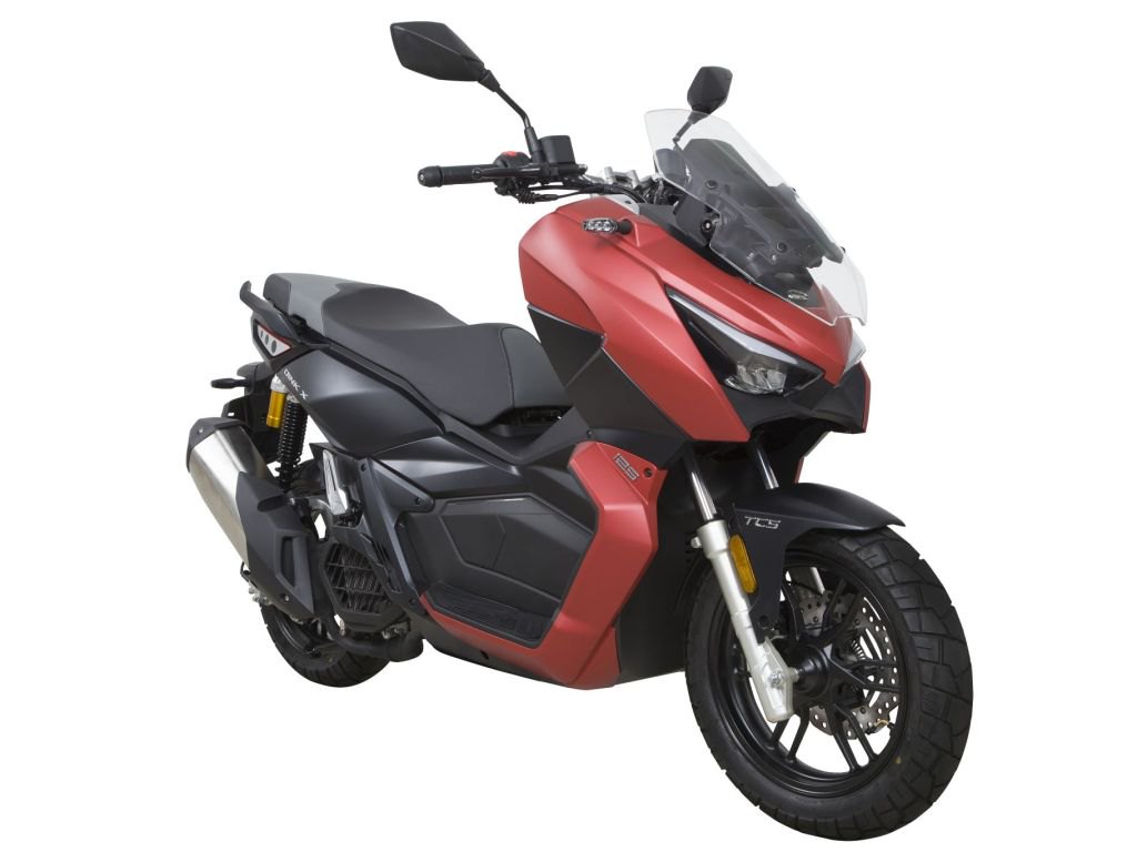 אופנוע Yamaha TMAX 560 בצבע כחול-שחור, צילום צד ימין בזווית גבוהה, בתערוכה עם מבקרים ברקע