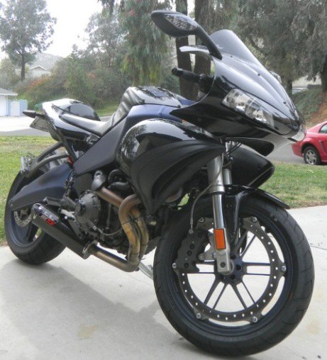 אופנוע שחור דגם Yamaha R6, צילום צד ימין על סלול, רקע של חצר ועצי עצי אלון