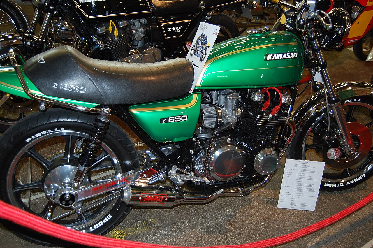 אופנוע Kawasaki Z650 ירוק עם פנסים כחולים וגלגלים Pirelli, מוצג בתצוגה עם רצועת אדום מקיפה, מראה צד קרוב