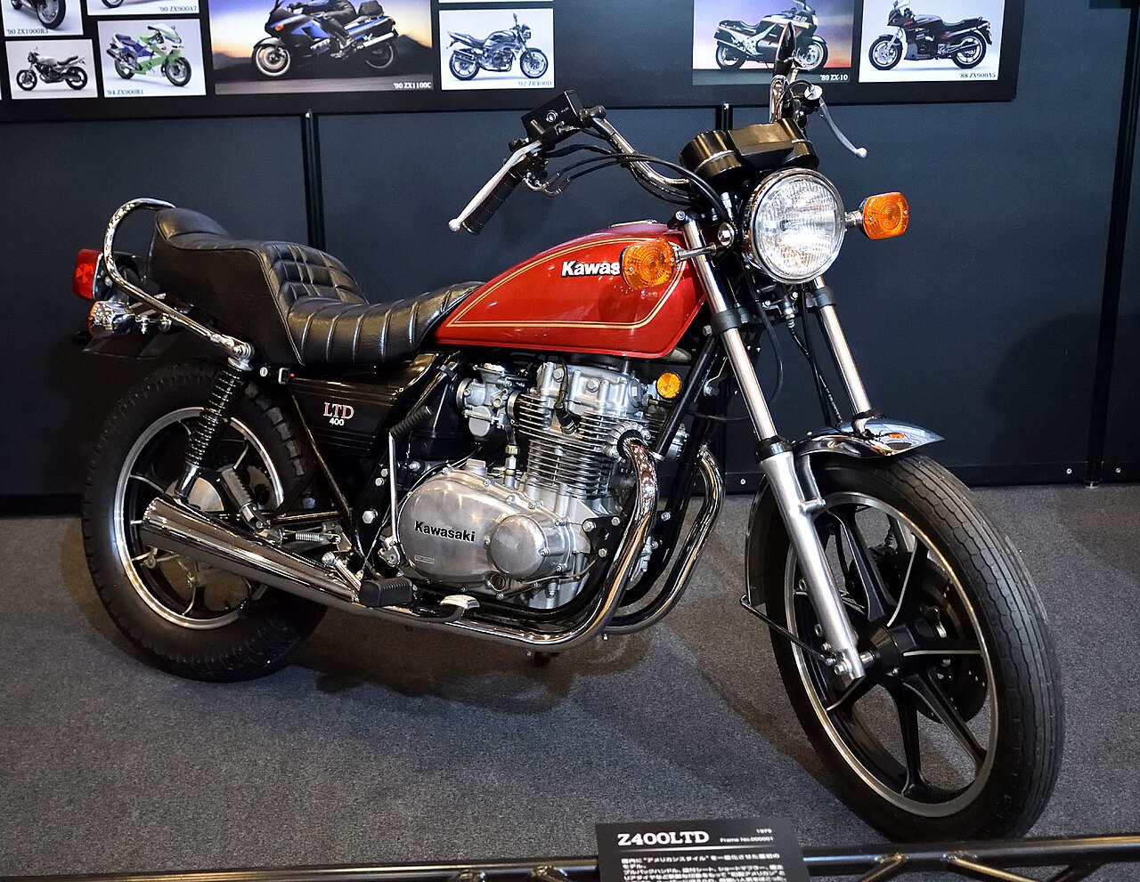 אופנוע קבצקי Z400LTD אדום עם מושב שחור, צילום צד קרוב, רקע עם תמונות אופנועים
