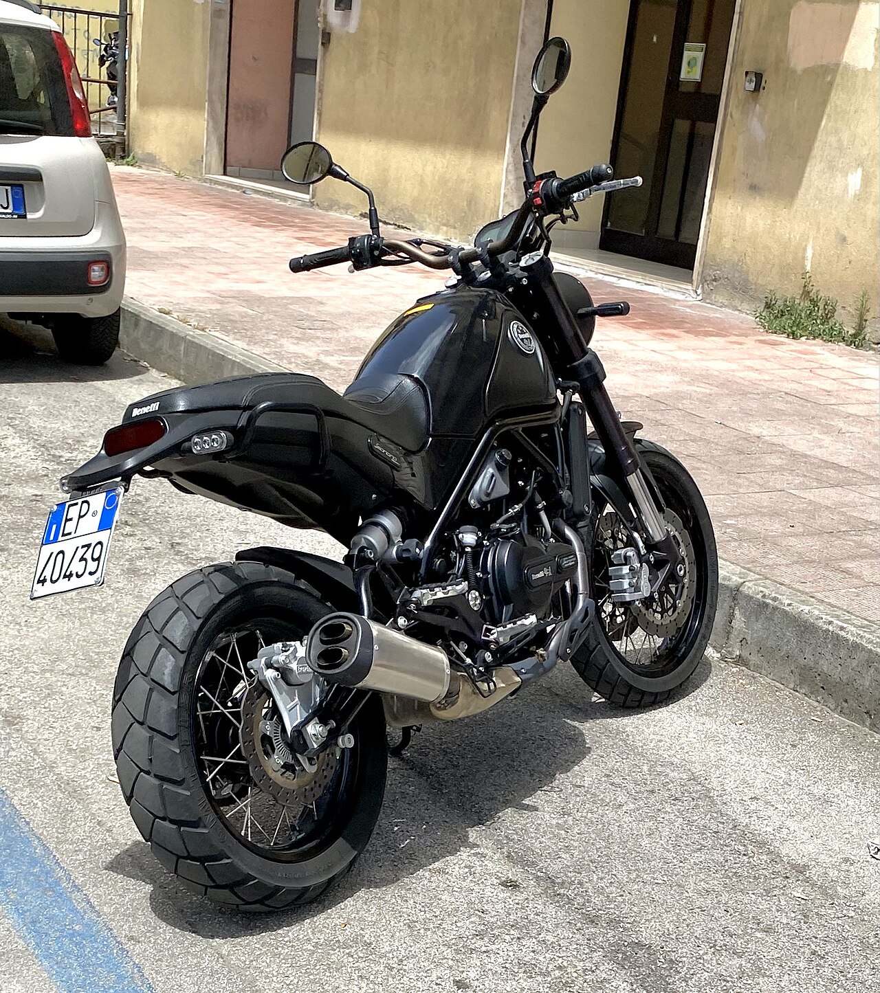 אופנוע Benelli 302S שחור, צילום מזווית אחורי-צדדי, חנייה ברחוב עירוני, גלגלים עם גומי עמידים, מראה ומנוע נראים בבירור.