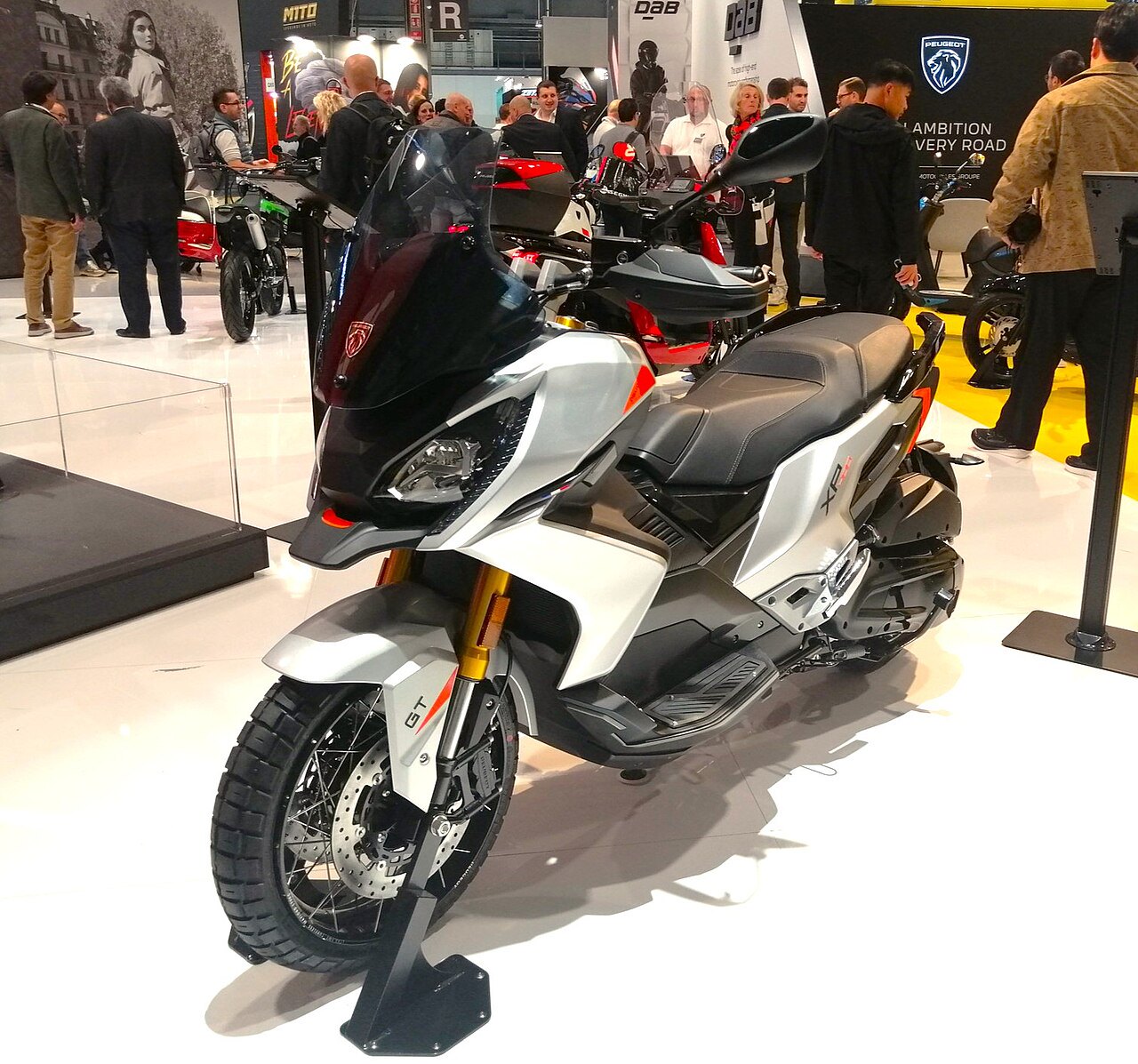 אופנוע אגרוף Peugeot XR6 GT לבן-שחור עם מנוע 600, מוצג בתערוכה עם זווית צילום שלצידו, מראה את המראה הקדמי והמושב, בסביבה של