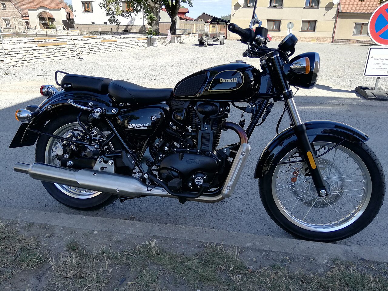 אופנוע Benelli Imperiale שחור, צילום צד, על רחוב אספלט, רקע של בניינים ומדרכה