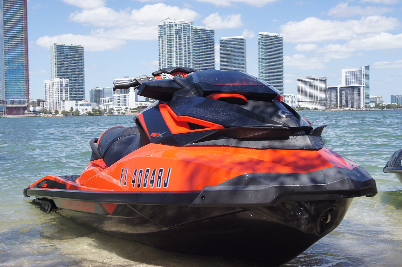 אופנוע ים אדום ושחור של Sea-Doo, עם רישום FL 4084RJ, בצל ערים בקופת ים, מצלמה קרוב מימין.