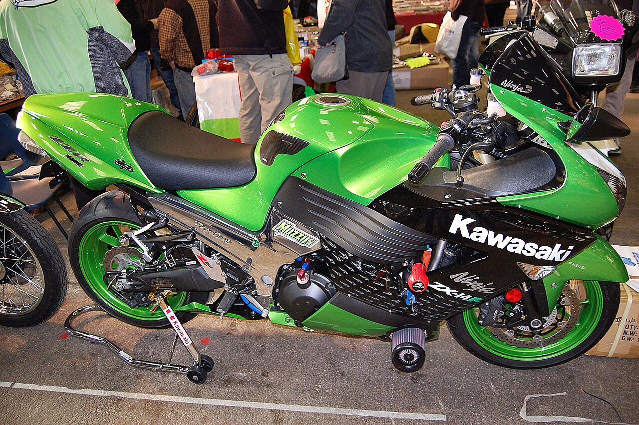 אופנוע Kawasaki ZX-14R ירוק בהיר עם פאנל שחור, צולם בזווית צדית בפער מוצגים, עם כתובות מותג ומודל ברורות.